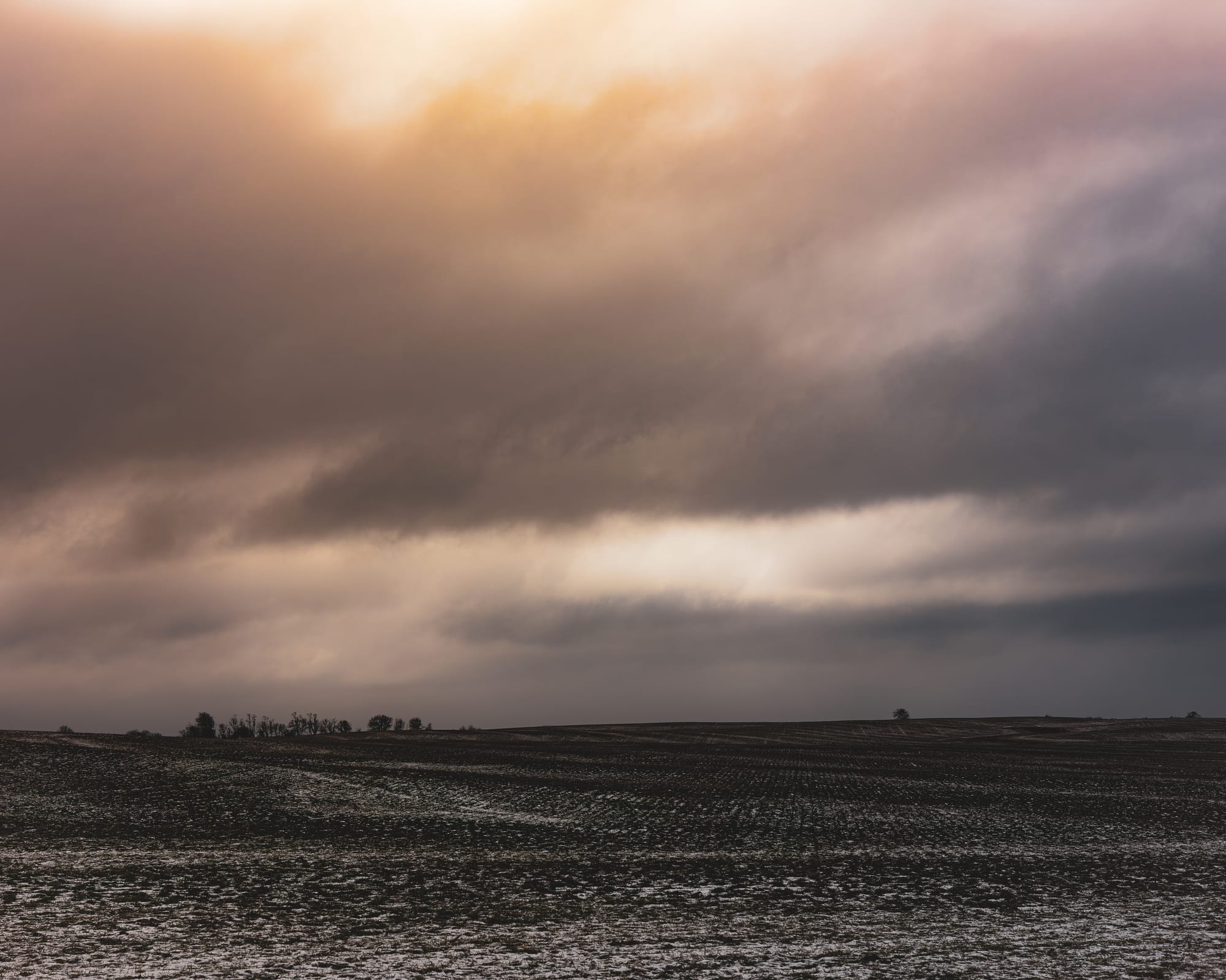 Storm clouds rolling over farmland