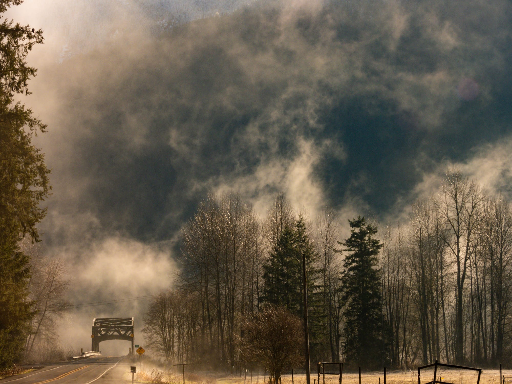 Misty road with bridge at dawn