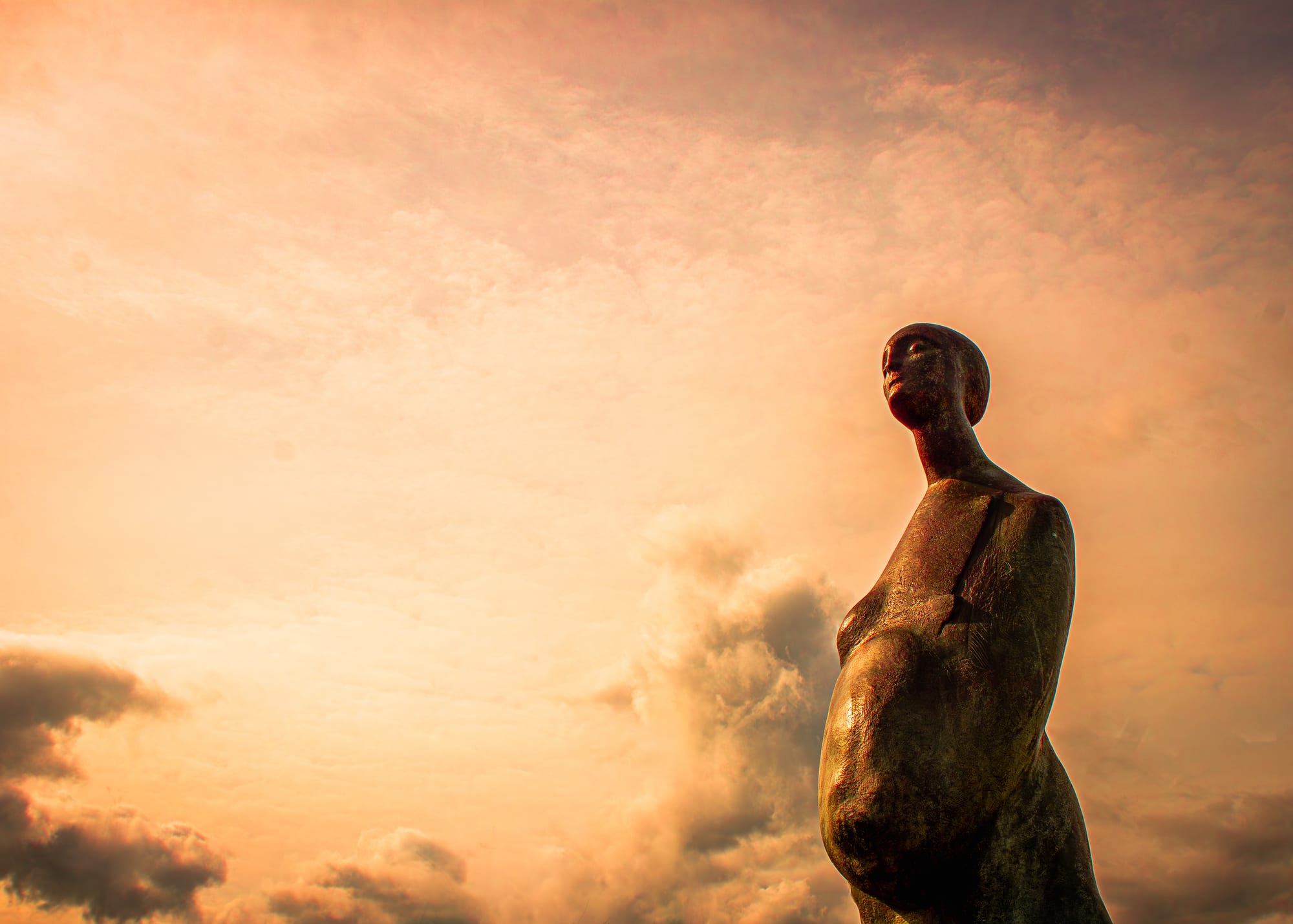Bronze statue silhouette at sunset