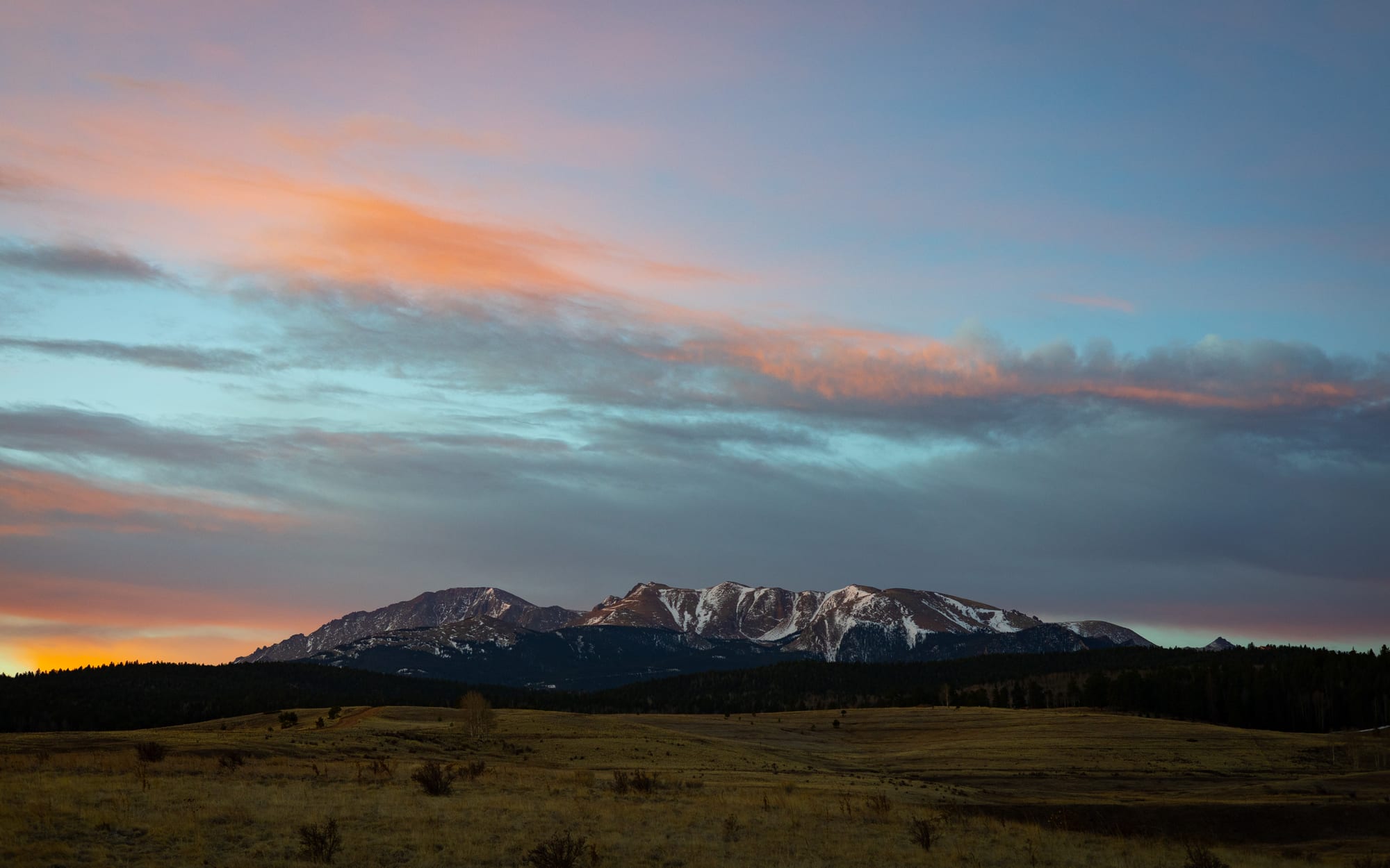 Mountain range at sunset with pink clouds